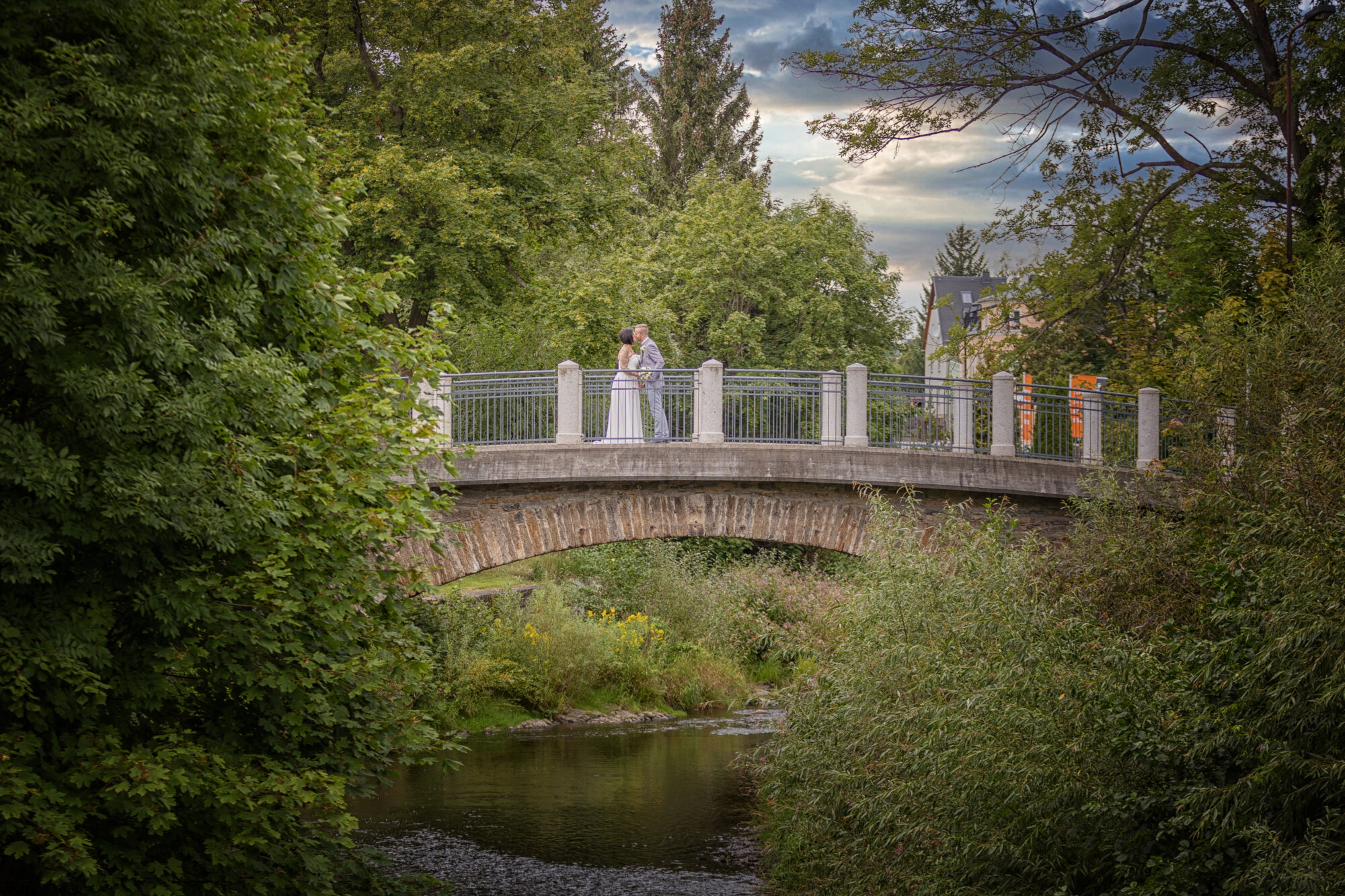 Steinbrücke über einen Bach im grünen Park – Hochzeitslocation, fotografiert von Marko Lorenz
