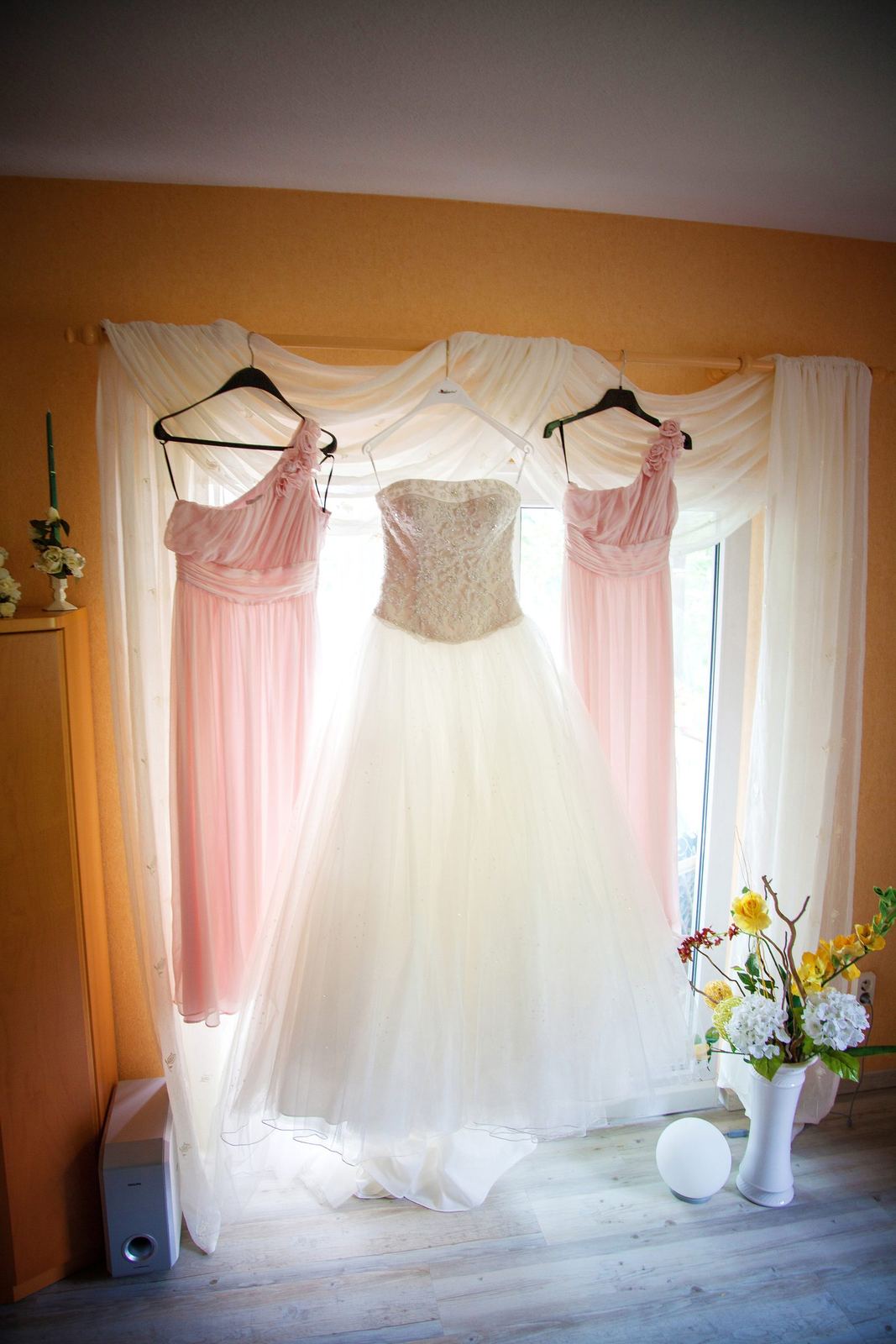 Brautkleid und Kleider der Brautjungfern am Fenster – Marko Lorenz, Hochzeitsfotograf