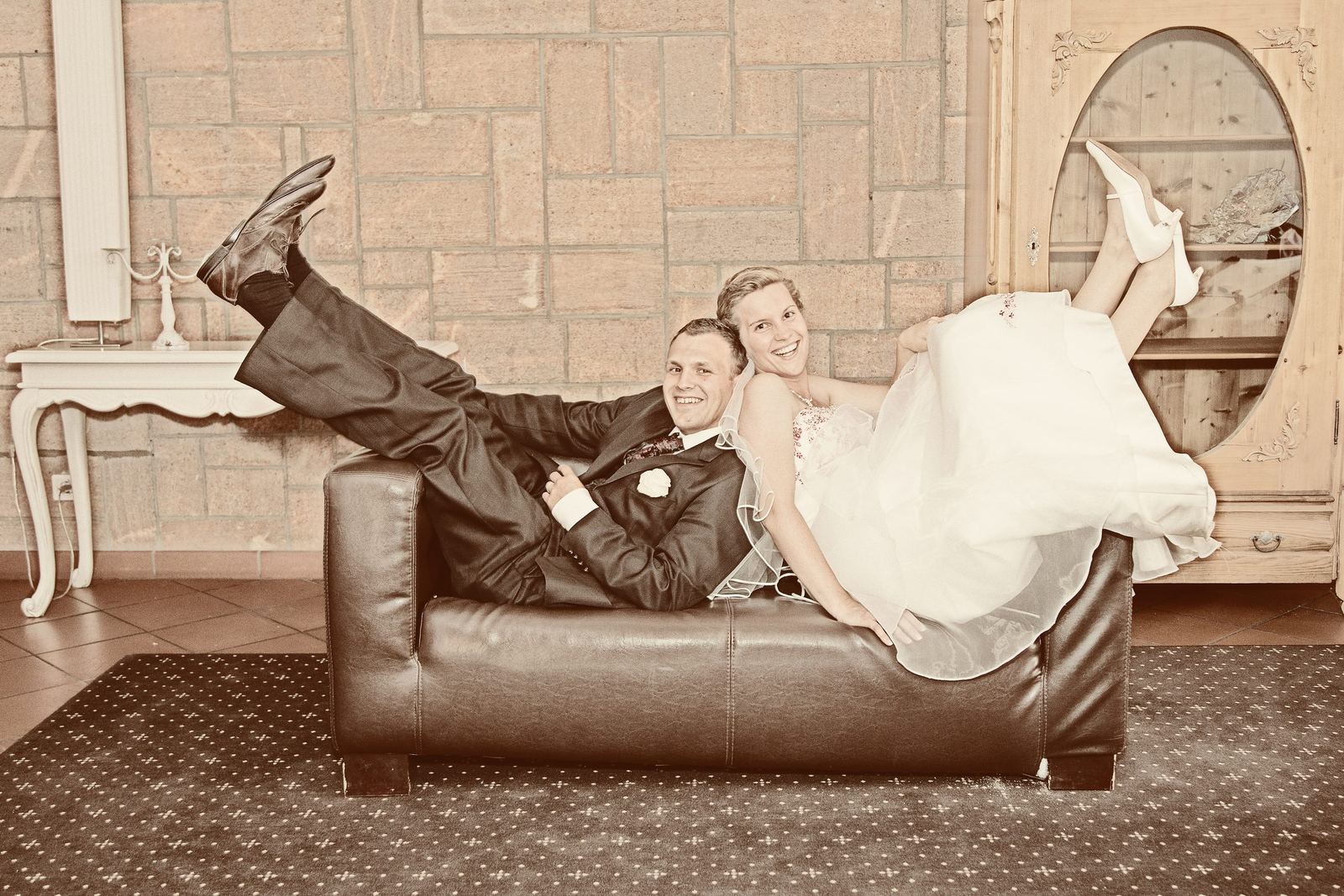 Brautpaar auf dem Ledersofa im Vintage-Stil – Marko Lorenz, Hochzeitsfotograf