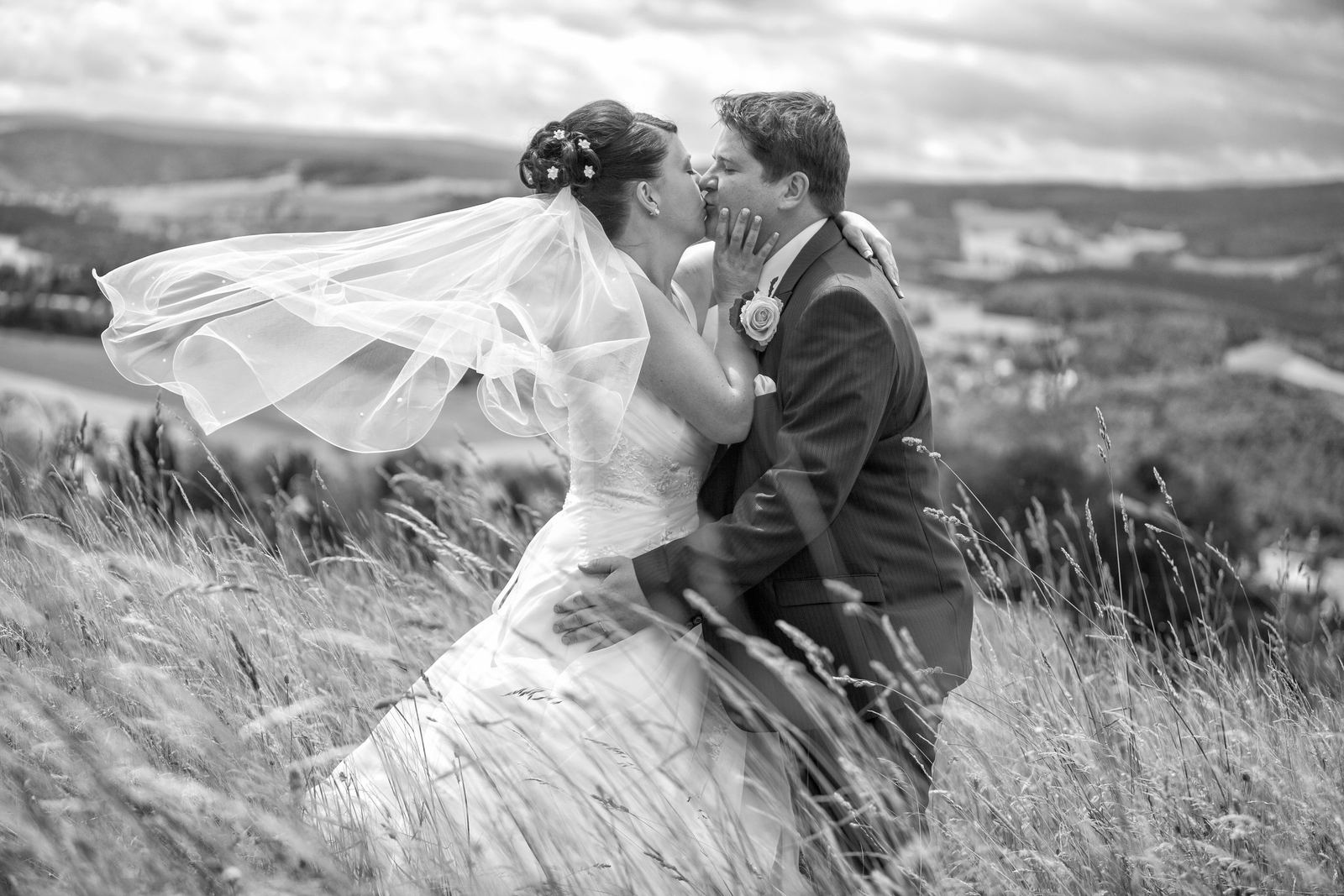 Brautpaar im Wind auf einer Wiese in Schwarz-Weiß – Marko Lorenz, Hochzeitsfotograf