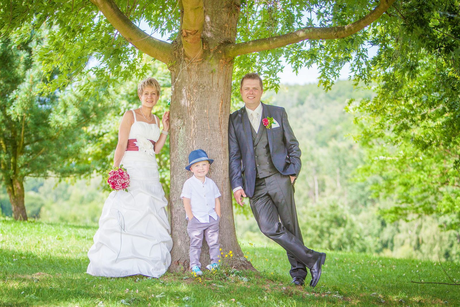Brautpaar mit ihrem kleinen Sohn unter einem Baum – Marko Lorenz, Hochzeitsfotograf