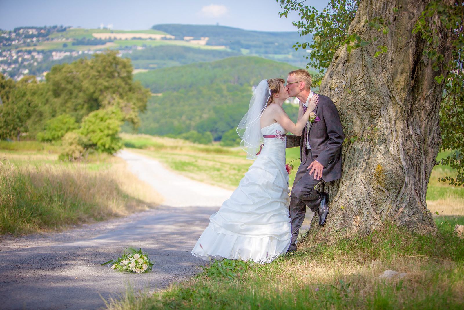 Kuss unter einem alten Baum mit Blick ins Tal – Marko Lorenz, Hochzeitsfotograf